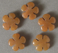 Five carved flower beads from yellow aventurine.
