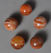 Five red agate sphere beads.