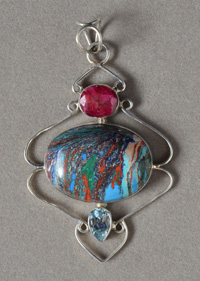 Rainbow calcite pendant with ruby and blue topaz accents.