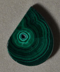 Malachite flat pendant bead in freeform drop shape.