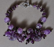 Bracelet from amethyst round, rondelle and carved beads.