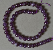 Strand of 8mm round beads from dark colored amethyst quartz.