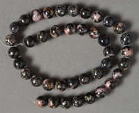 Black and pink rhodonite round bead strand.