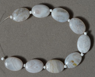White Mexican agate flat oval beads.