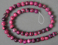 Rhodonite round beads which have been dyed.