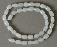 Milky white Jade barrel beads on strand.