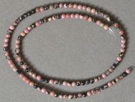 Small round beads from pink and black rhodonite.