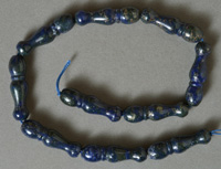 Lapis Lazuli beads carved in ornate bottle shape.
