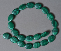 Flat oval beads from green malachite.